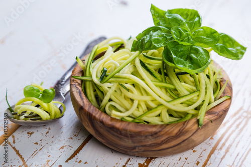 Raw zucchini pasta on white background photo