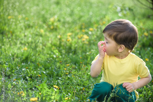 Little caucasian boy has allergies from yellow flower.