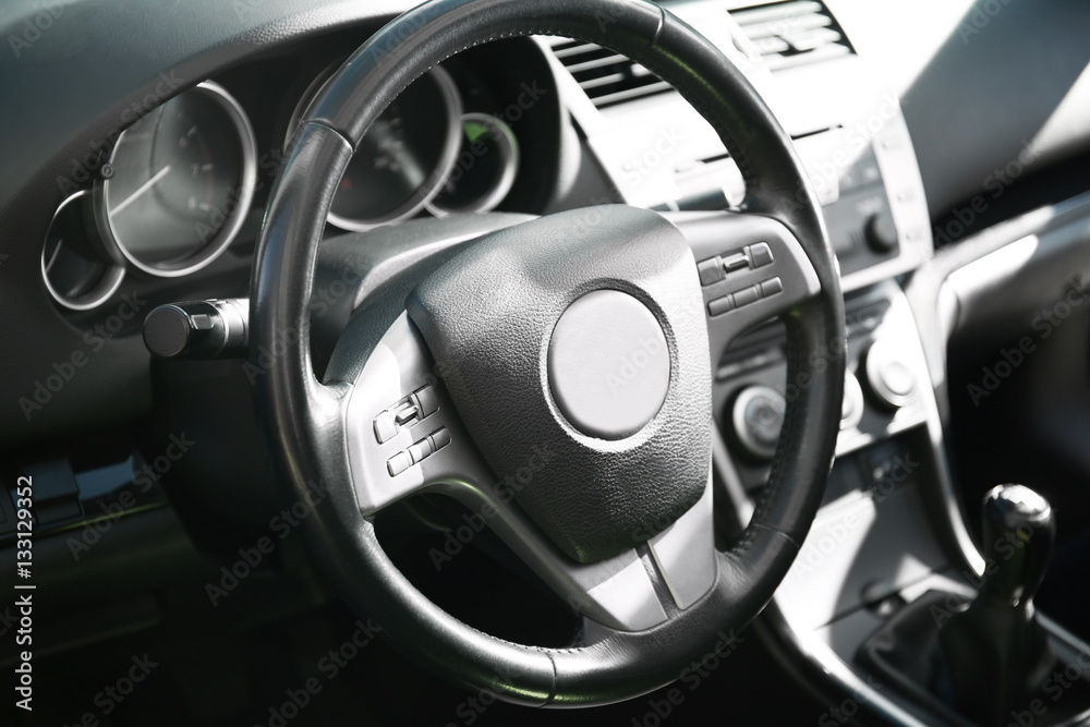 Steering wheel in car interior, closeup
