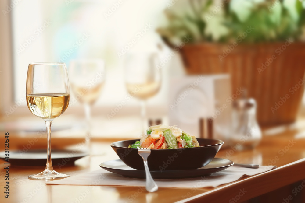 Plate with delicious salad on served table in cafe