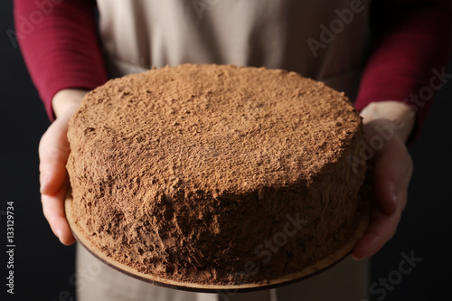 Woman holding chocolate cake, closeup