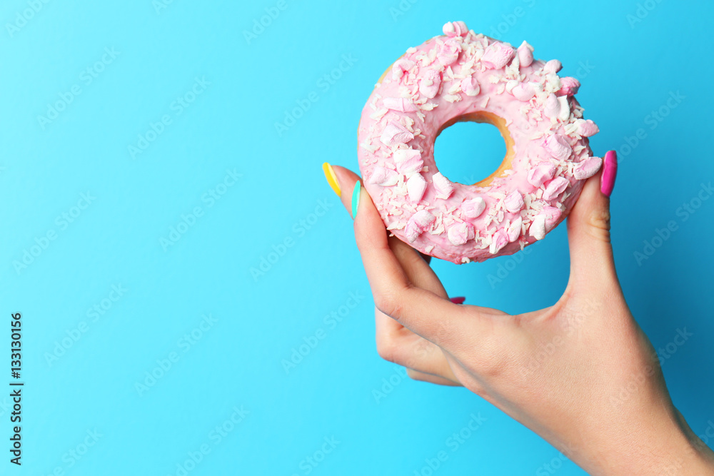Εκτύπωση καμβά Woman holding delicious donut on color  background