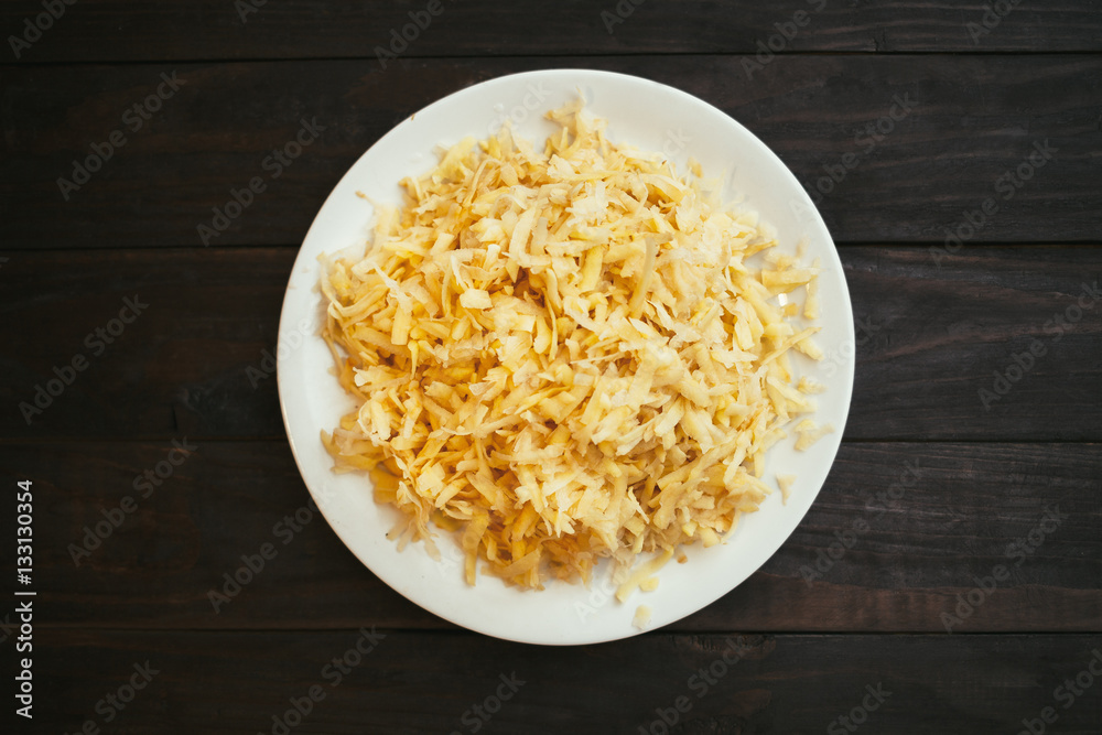 The raw grated potato on a plate The raw grated potato on a plate