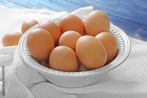 Plate with raw eggs on tablecloth
