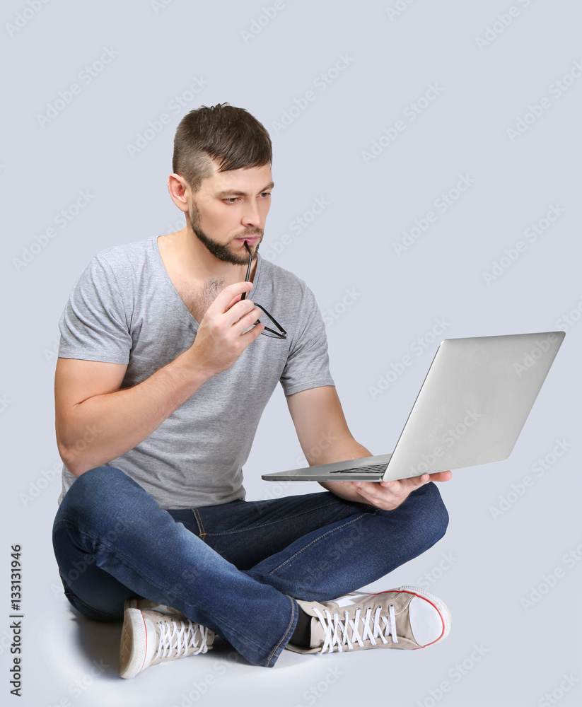 Handsome young programmer with laptop on color background Stock Photo ...