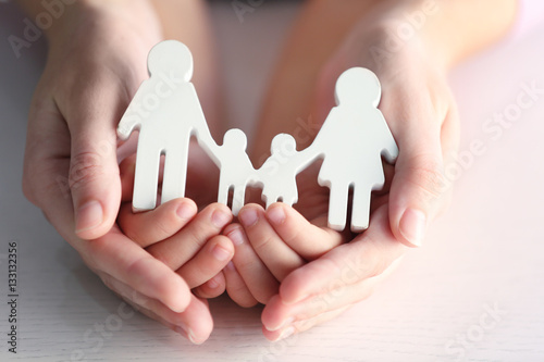 Child and adult person holding figure in shape of happy family, closeup. Adoption concept photo