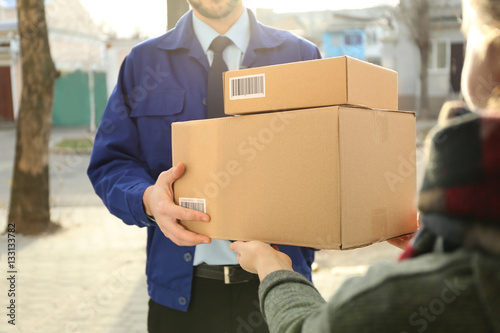 Courier giving parcels to c...