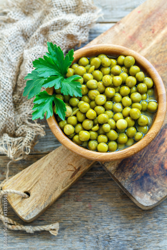 Bowl with canned green peas and sprig of parsley. Bowl with canned green peas and sprig of parsley.