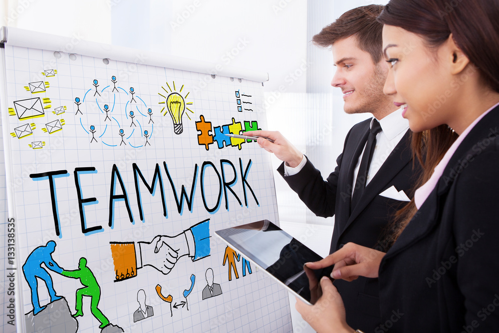Businesspeople Discussing Teamwork Concept On Flipchart Businesspeople Discussing Teamwork Concept On Flipchart