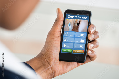 Fototapeta Naklejka Na Ścianę i Meble -  Person Using Smart Home System On Mobilephone