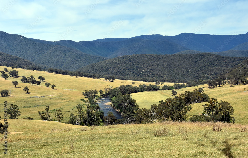 Broad panorama of the countryside in High Country, Victoria with green field in foreground. Grassy hills near Dargo, in Australia.