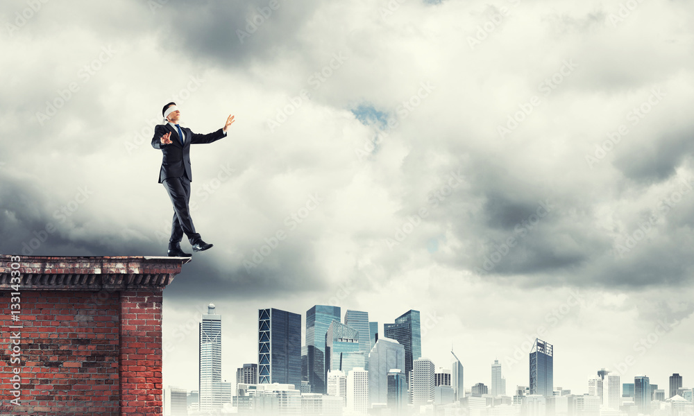 Danger and risk concept with businessman making step from edge Danger and risk concept with businessman making step from edge
