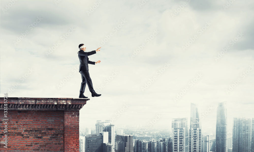 Danger and risk concept with businessman making step from edge Danger and risk concept with businessman making step from edge