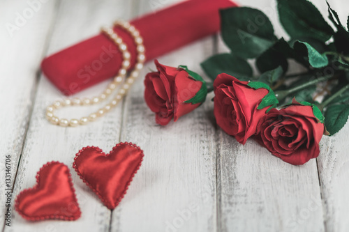 Red roses and Valentine's day hearts on wooden background. copy space