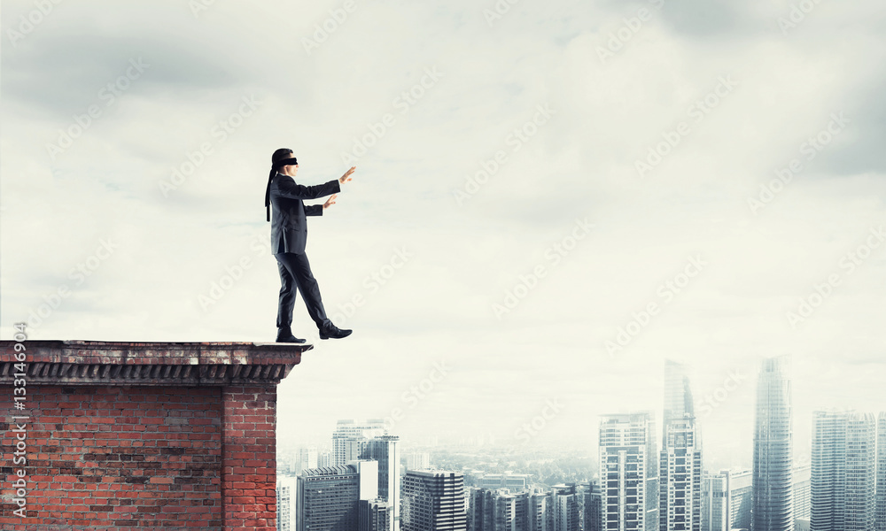 Danger and risk concept with businessman making step from edge Danger and risk concept with businessman making step from edge
