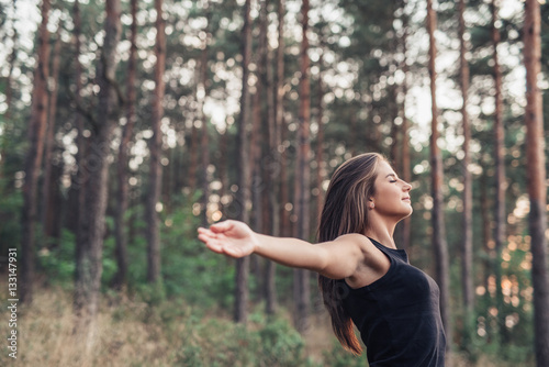 Young woman raising her arms to nature
