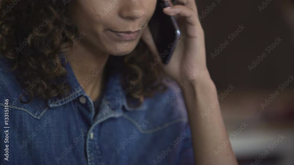 Curly mixed race woman answering phone call, young architect working in office Curly mixed race woman answering phone call, young architect working in office