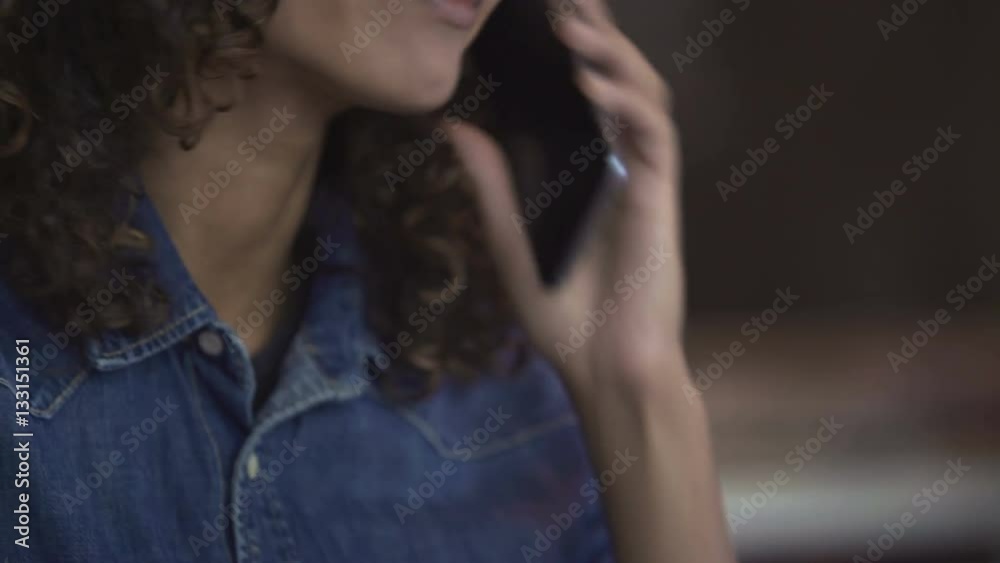 Beautiful curly biracial woman talking on smartphone and smiling, emotions Beautiful curly biracial woman talking on smartphone and smiling, emotions