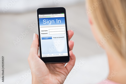 Woman Holding Mobile Phone Showing Log In Page