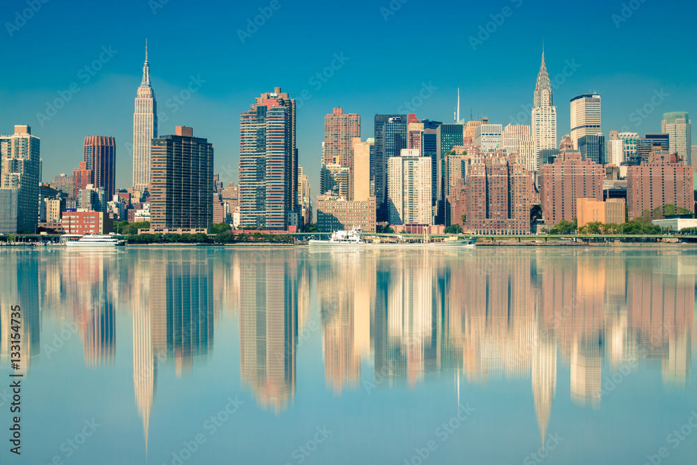 New York City view of Manhattan and The East River with reflections of NYC buildings. 