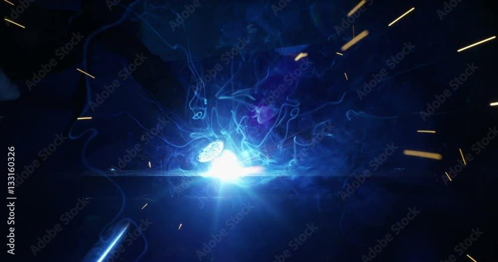 .A blacksmith or welder, with his welder, welding steel and iron, in extreme slow motion. The welder uses a mask to protect your eyes from sparks. concept: manual work, blacksmith, industry, welder
