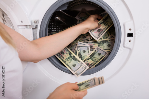 Person Inserting Money In Washing Machine