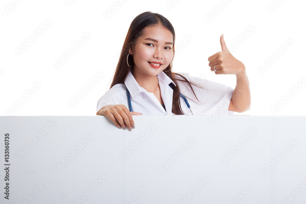 Young Asian female doctor show thumbs up behind blank white bil Young Asian female doctor show thumbs up behind blank white bil