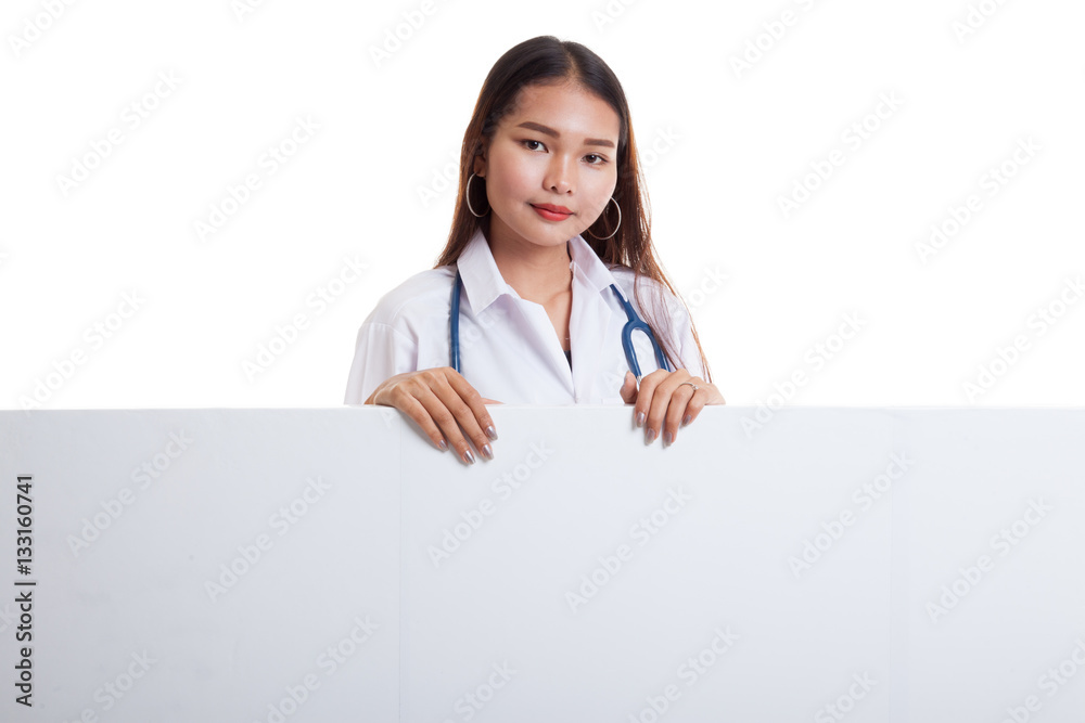 Young Asian female doctor show thumbs up behind blank white bil Young Asian female doctor show thumbs up behind blank white bil