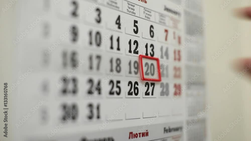Close up of female hand shift red mark frame, save the date on wall calendar.