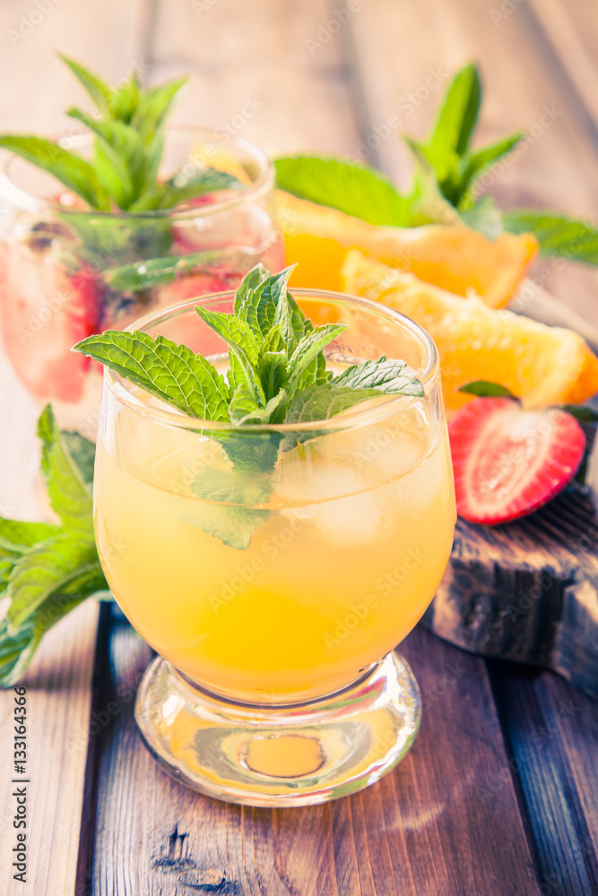 drinks with strawberry and orange in a glass on a table, selective focus