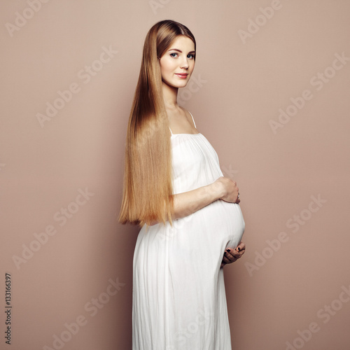 Portrait of the young pregnant woman. Pregnancy, love, people and expectation concept. Happy pregnant lady with long hair