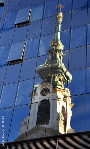 Turm der Schottenkirche im Spiegelbild einer Glasfassade photo