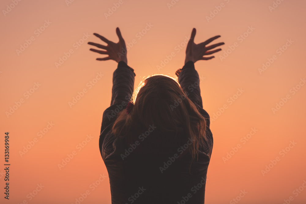 Silhouette of a woman at sunset / sunrise time.