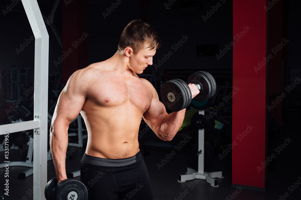 Closeup portrait of professional bodybuilder Strong muscular yang man doing exercise. Workout with barbell at gym.  Sports and fitness. Training  guy pumping up hands biceps. 