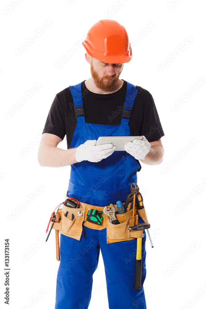 Man builder in the uniform with a tablet in the hands Man builder in the uniform with a tablet in the hands