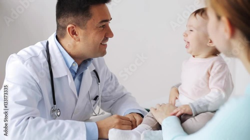 happy woman with baby and doctor at clinic