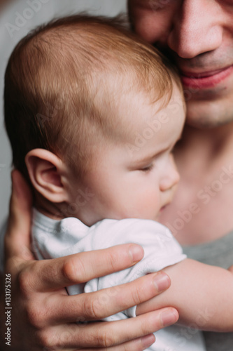 Portrait of loving father with baby boy 4-6 months his son at ho