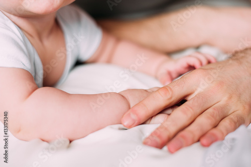 holding hands of loving father with baby boy 4-6 months his son