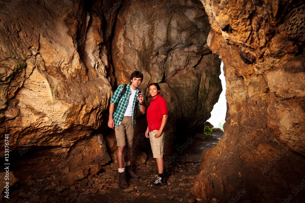 Young Couple Exploring A Cave