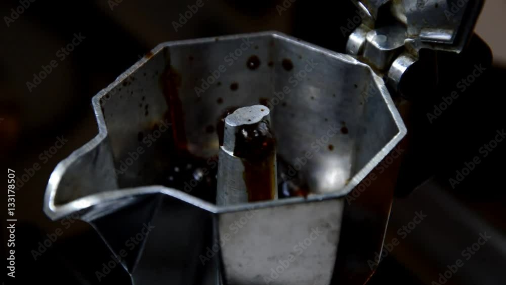 Closeup of the coffee brewing through the nozzle of a moka pot Closeup of the coffee brewing through the nozzle of a moka pot