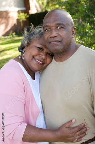 Mature African American couple laughing and hugging.