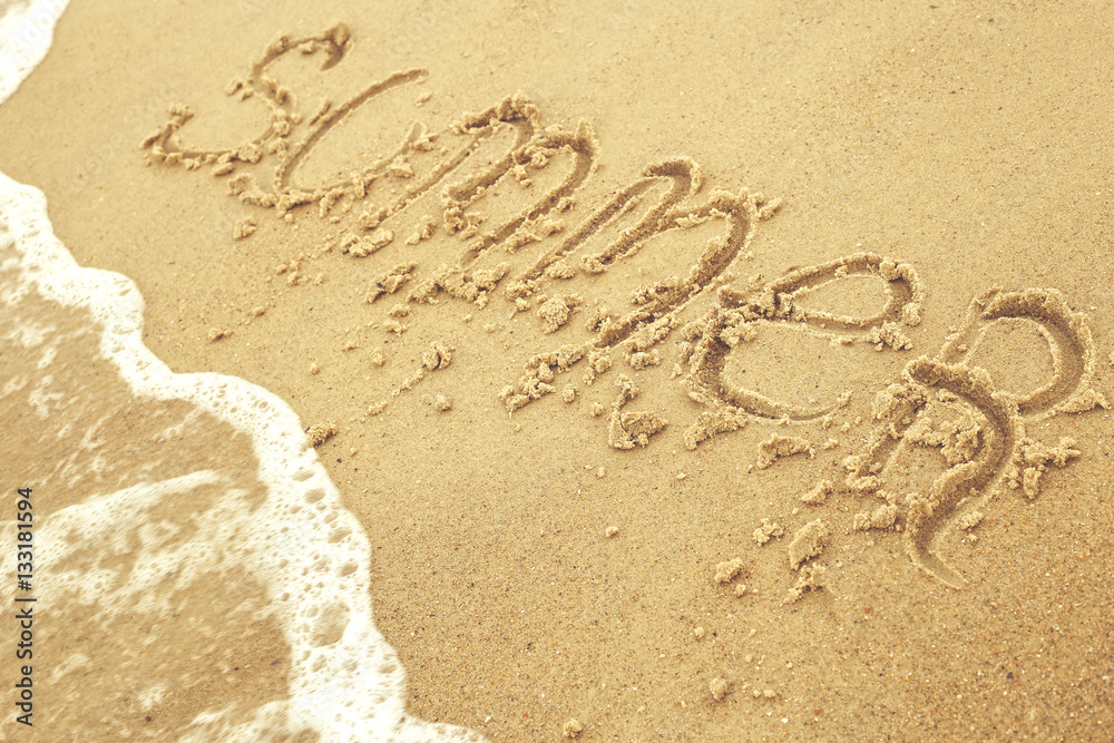 Summer inscription on the sand at the beach as concept of family vacations at the sea Summer inscription on the sand at the beach as concept of family vacations at the sea