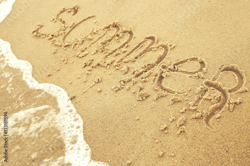 Summer inscription on the sand at the beach as concept of family vacations at the sea