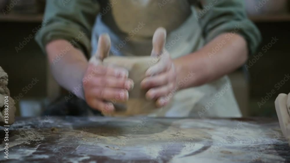 Potter works with clay. Making pots and other products Potter works with clay. Making pots and other products