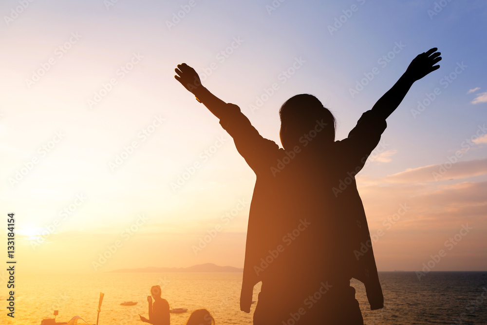 Fototapeta premium silhouette woman hands up at the beach