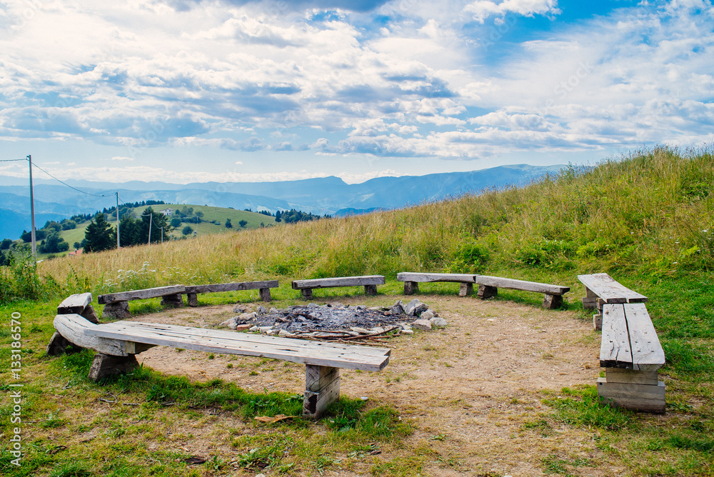 Benches around an extinguished campfire in mountain Benches around an extinguished campfire in mountain