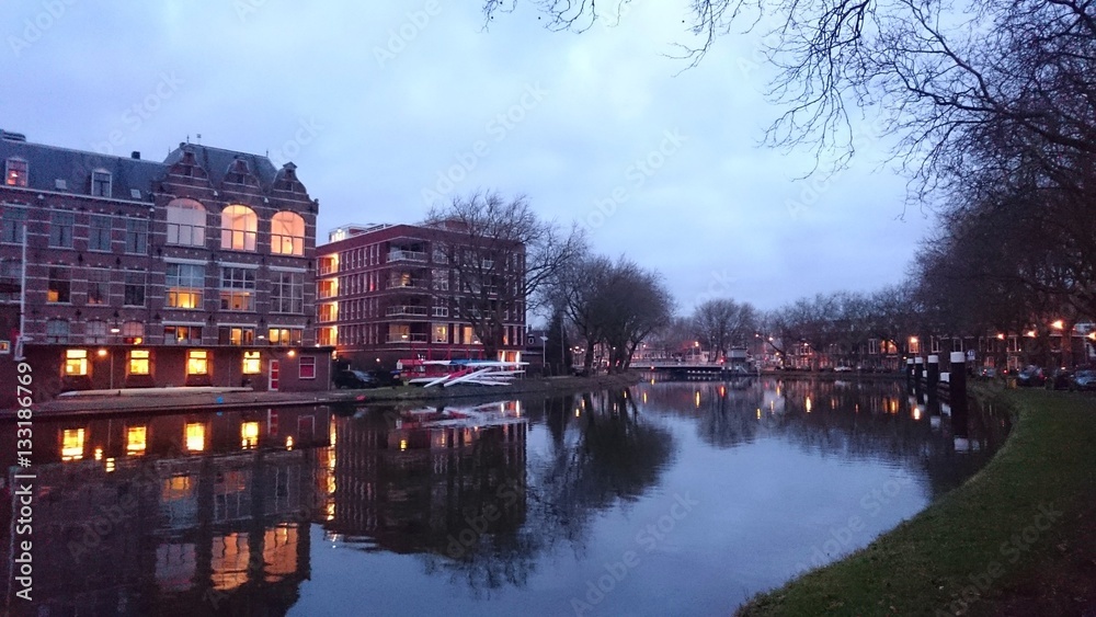 The navigation channel Rijnschiekanaal in Delft, the Netherlands, by twilight. View to the Oostpoortbrug (the East Gate Bridge).