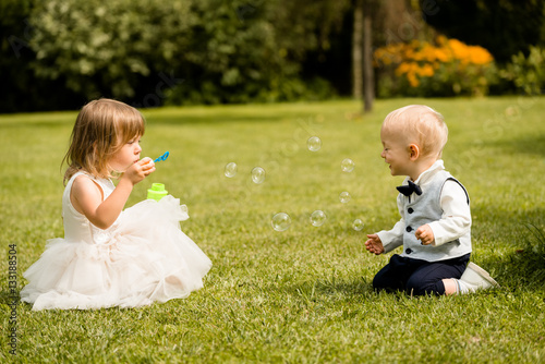 Children playing with bubbles in summer park