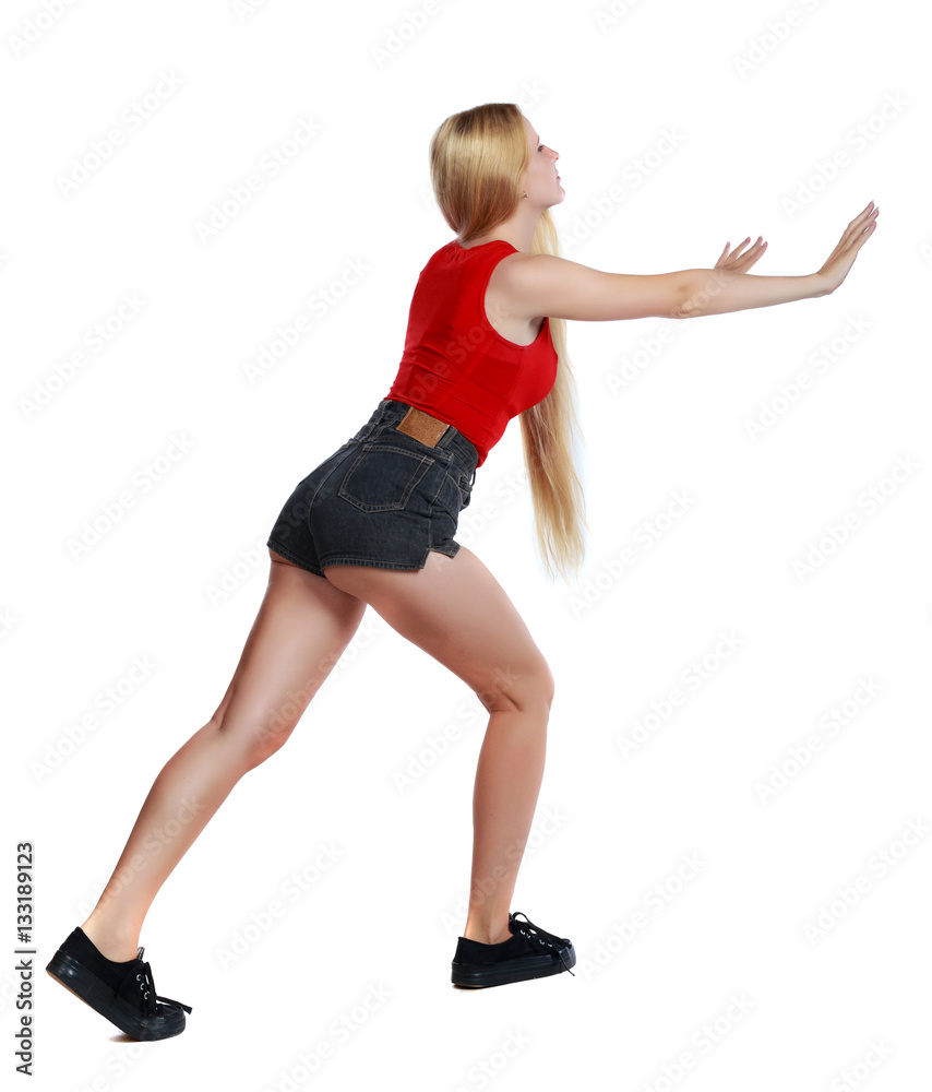 back view of woman pushes wall. Isolated over white background. Rear view people collection. backside view of person. Long-haired blonde in shorts shove the wall in front of him. back view of woman pushes wall. Isolated over white background. Rear view people collection. backside view of person. Long-haired blonde in shorts shove the wall in front of him.