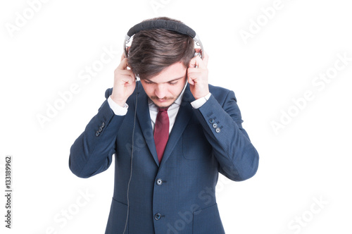 Business man standing looking down and putting on headphones